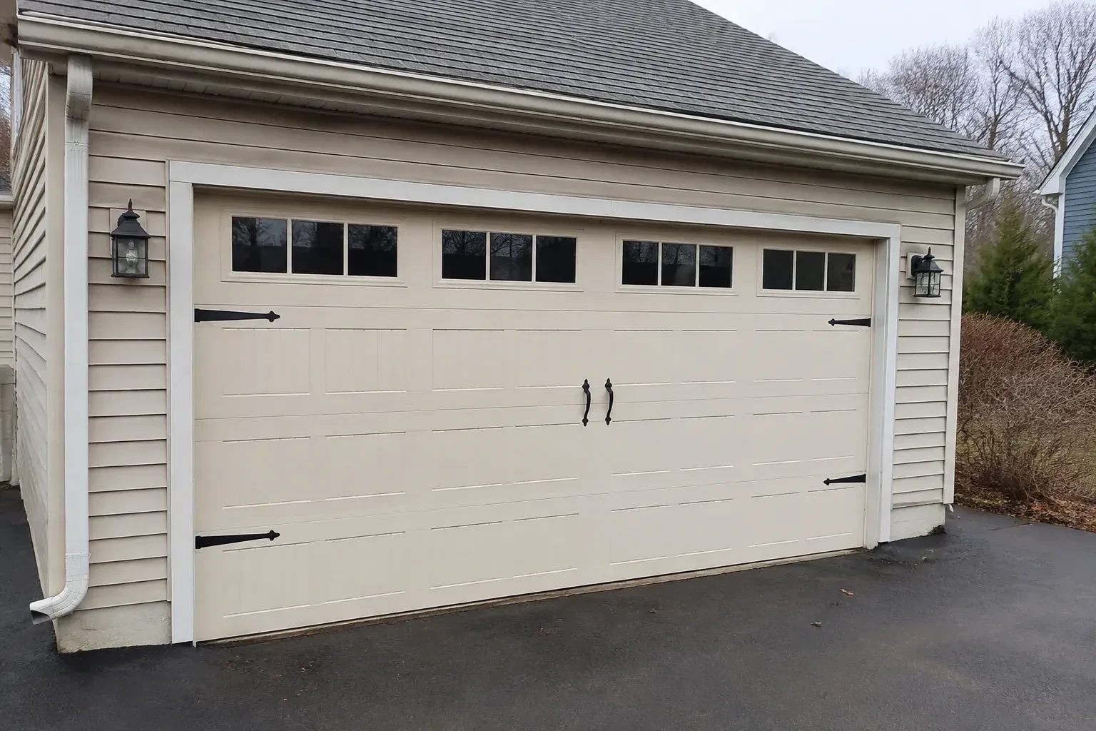 Cream carriage-house-style garage door with dark decorative hardware. — Carriage-House Garage Door Installation, London